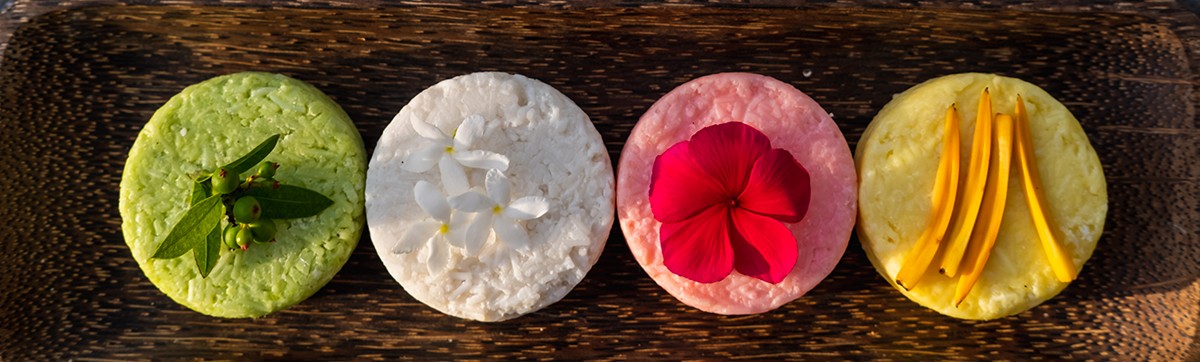 Variety of different natural eco friendly colorful solid shampoo bars, conditioner or soaps on stone background. Zero waste and sustainable plastic free lifestyle concept